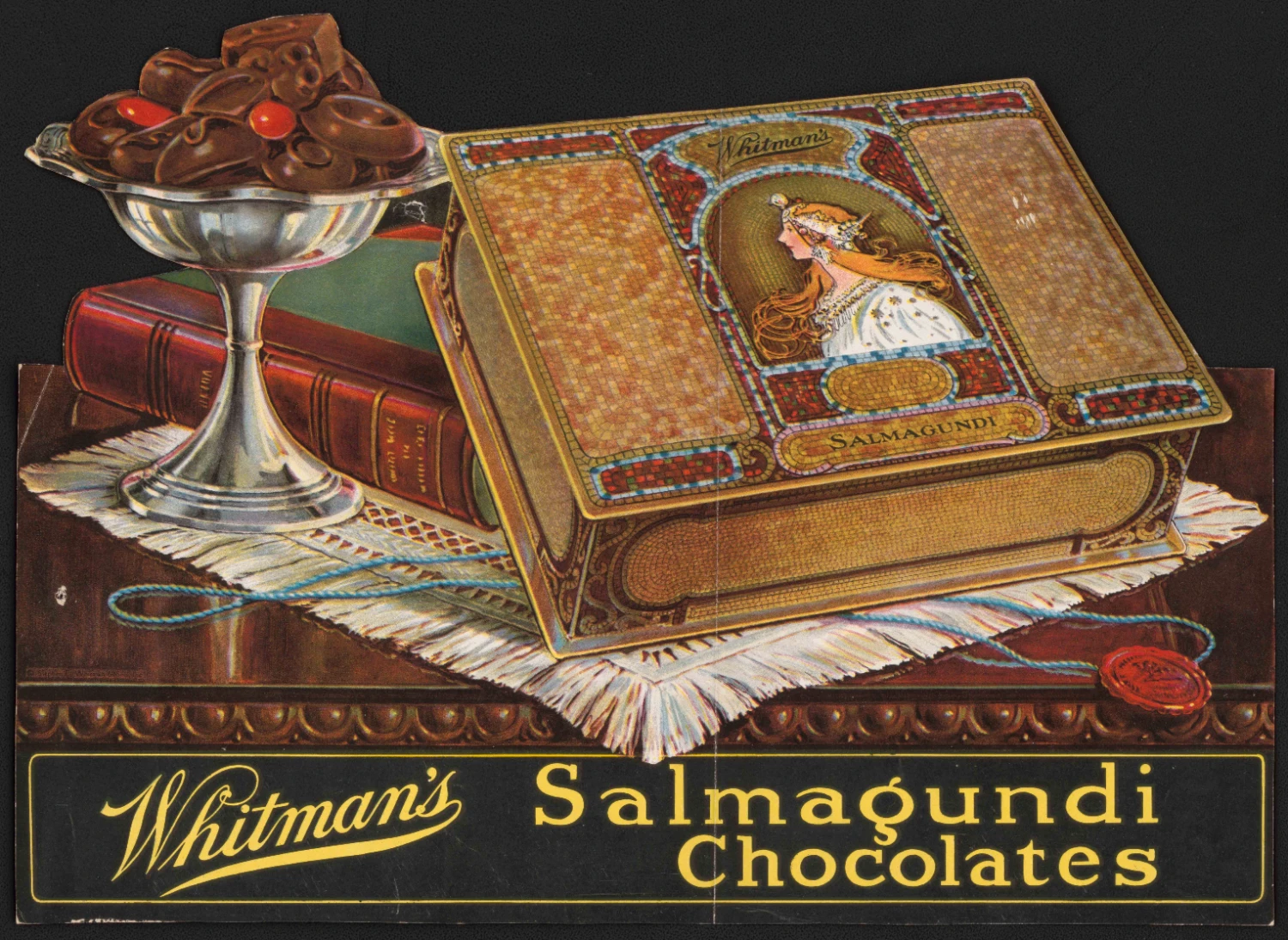 Color advertising poster for Whitman’s Salmagundi chocolates showing an ornate decorative box on a table beside a silver dish of chocolates and stacked books against a dark background.